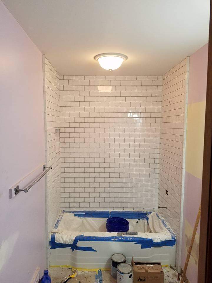 White subway tile tub surround with recessed niche, during installation